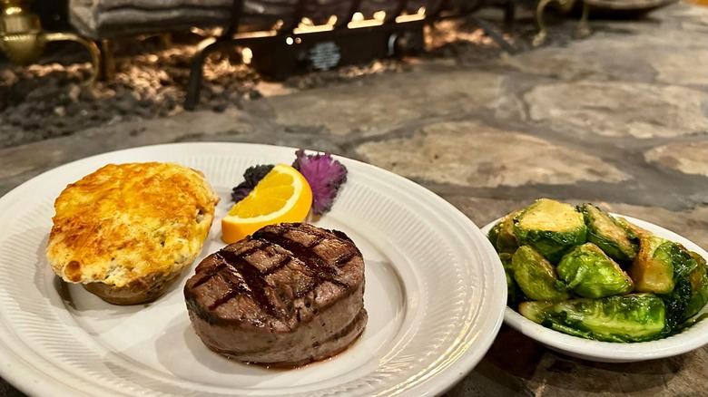 Steak and potato with side of Brussels sprouts on stone background