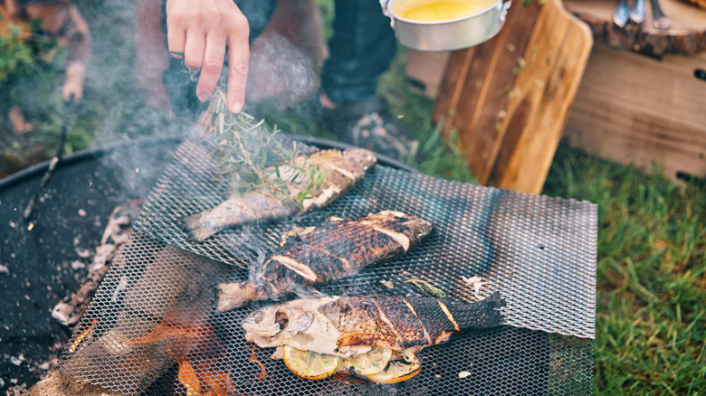 whole fish grilling over fire