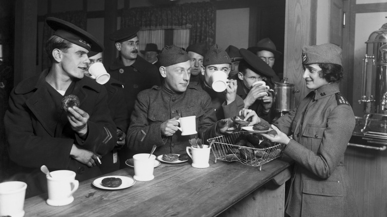 A woman serving donuts to American troops during World War I.