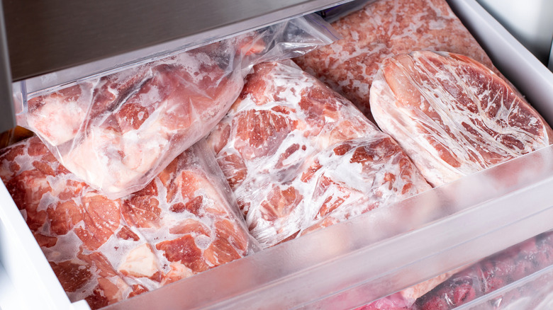 A freezer drawer filled with bagged, frozen meat