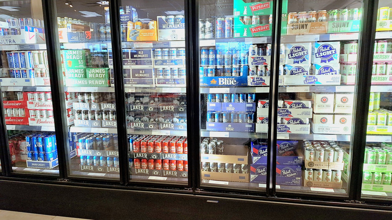 different cans of beer in a refrigerated section