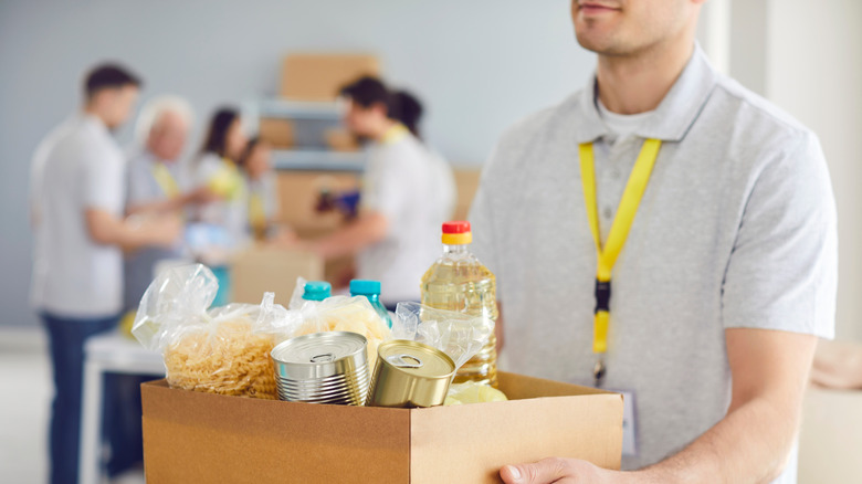 A person carrying a box of donated food items