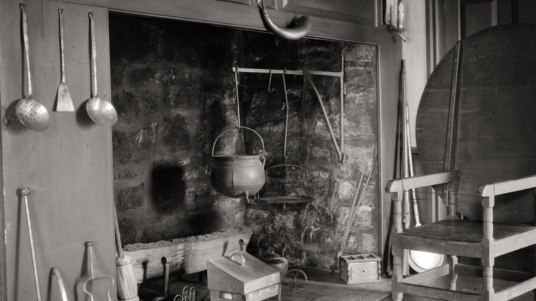 18th century colonial fireplace with pot hanging from rod