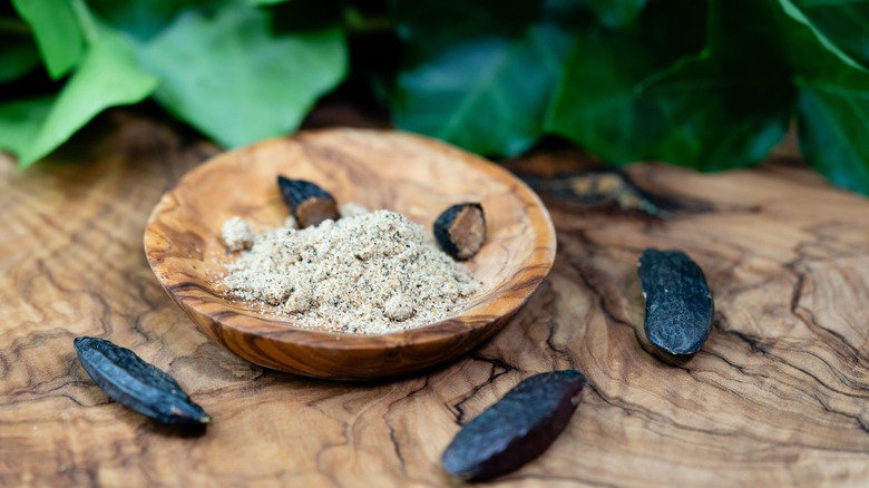 whole and grated tonka beans in a wooden bowl