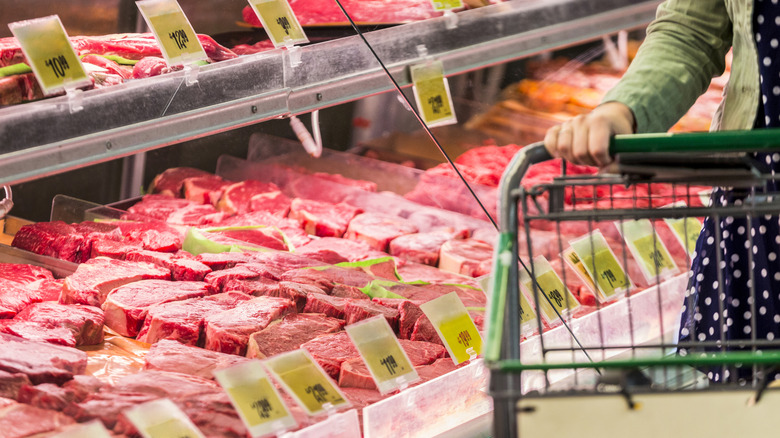person shopping for meat in grocery store