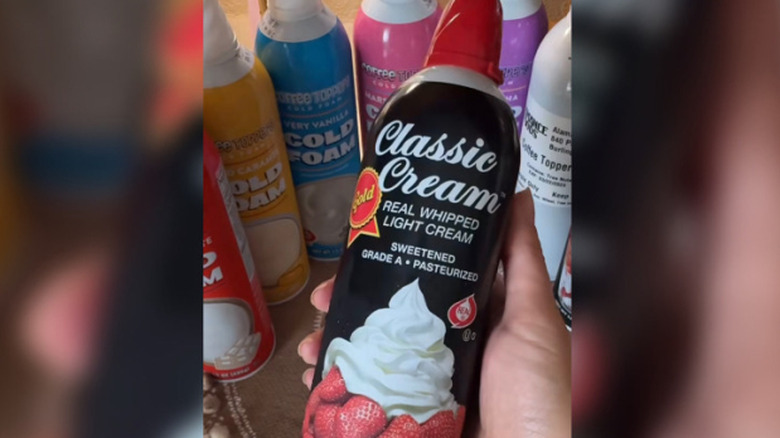 Someone holding a canister of Classic Cream Real Whipped Light Cream