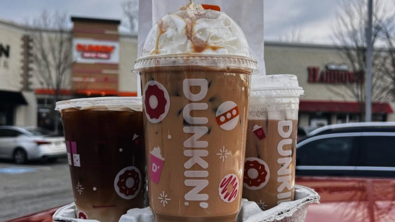 Three Dunkin's iced coffees on a car roof