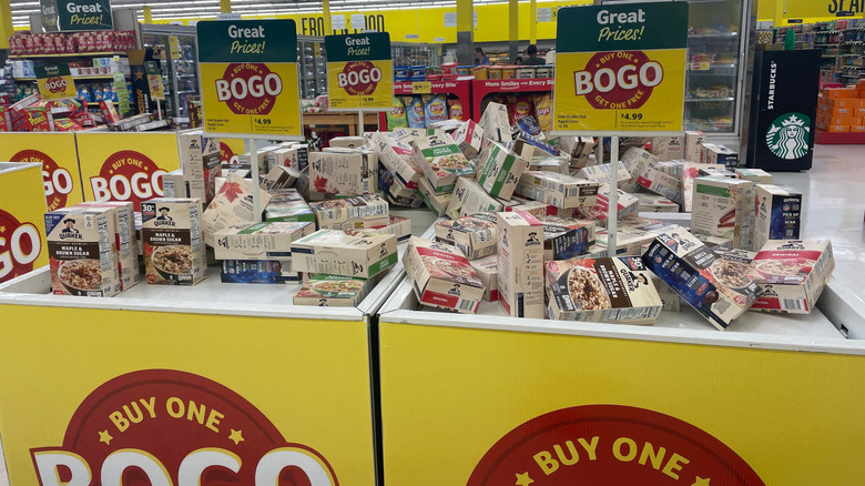 A grocery store display featuring Quaker Oatmeal on sale with a buy one get one free deal