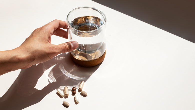 someone reaching for water and asprin