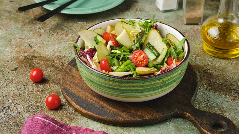 Fresh green salad with pears and tomatoes in a bowl