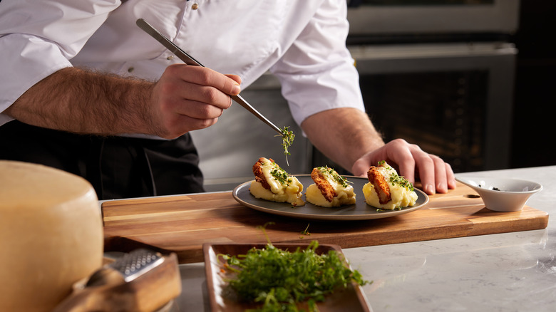 chef preparing meal on wooden board