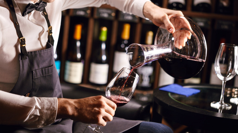 Wine being poured from a decanter into a glass