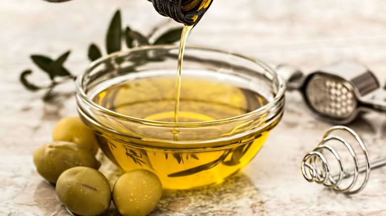 pouring olive oil into bowl