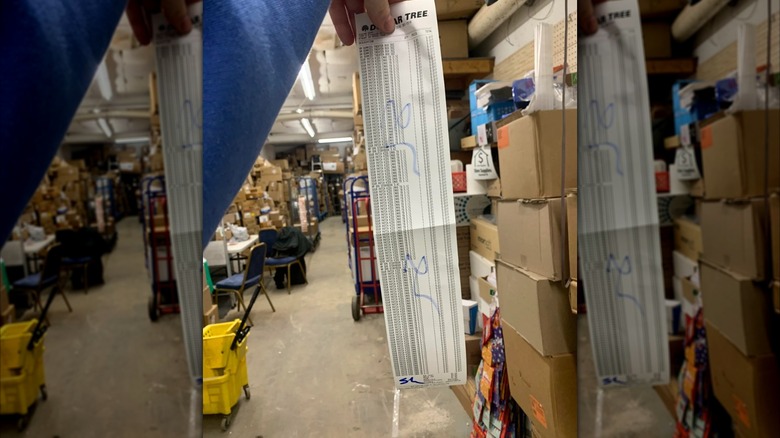 Hand holds up long receipt with Dollar Tree penny items with store room in background