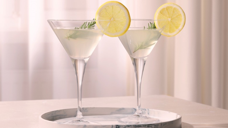 Two garnished martinis on a tray