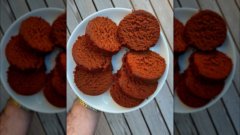 Hand holding plate of sliced canned bread