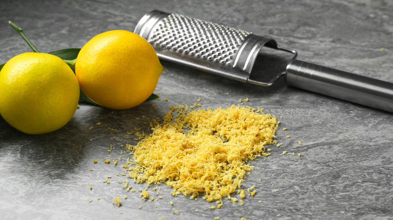 Lemon zest below zester and whole lemons