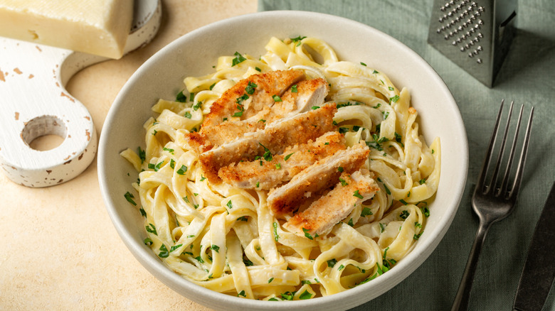 fetuccini alfredo with chicken on a white plate