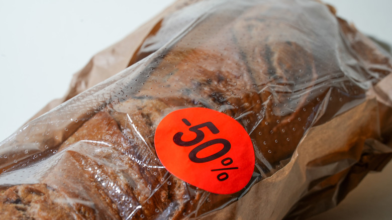A close-up of bread in a bag with an ornage -50% sticker.