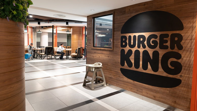 Interior of Burger King with a large sign on the wooden wall