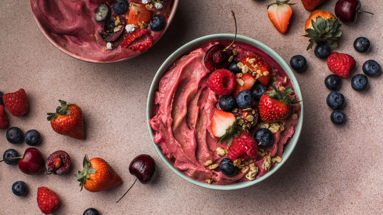 Two açai bowls with berries