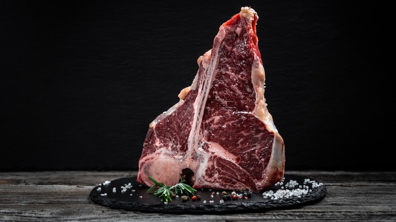 raw porterhouse steak on slate