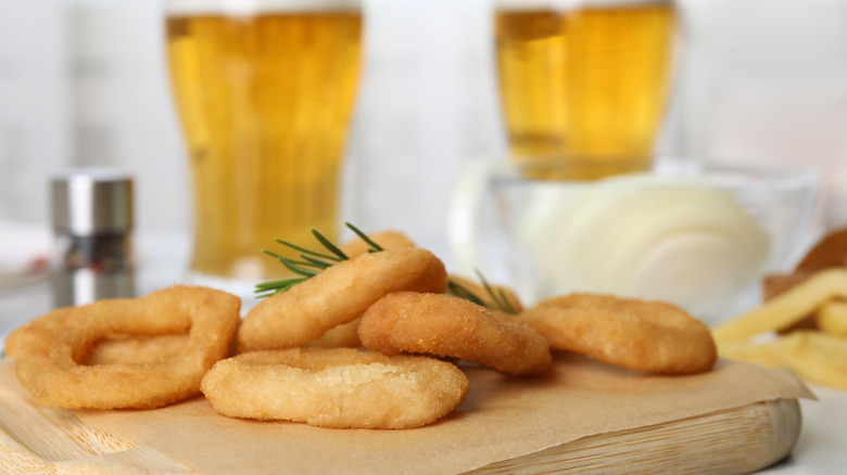 Beer-battered onion rings with beer in the background