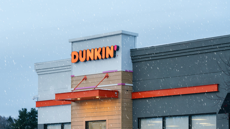 A Dunkin' location on a cloudy, snowy day