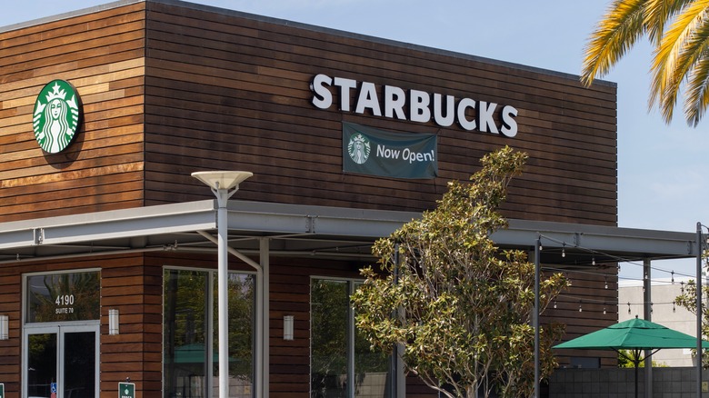 A Starbucks location with wood siding and a "Now Open!" sign