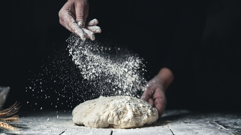 Sprinkling flour on bread dough