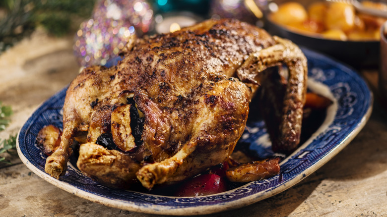 close up of roast duck on blue plate