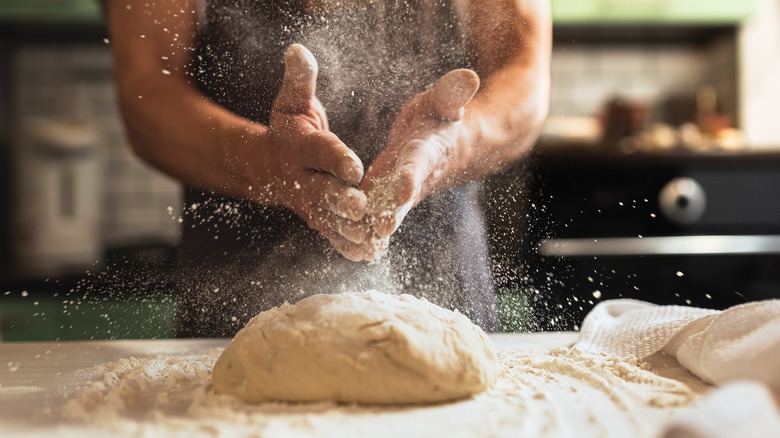 Floured hands and dough