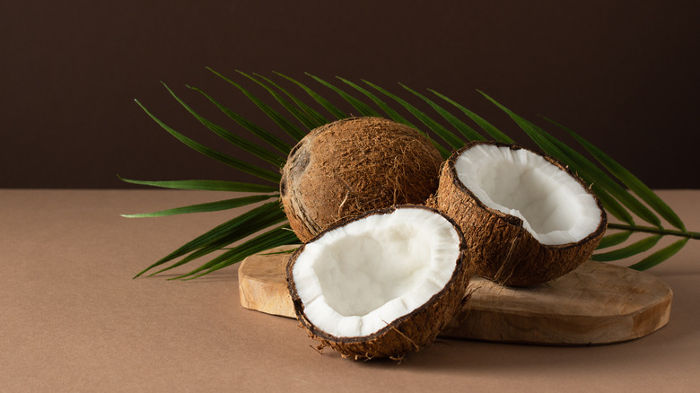 Two coconuts on wooden slab