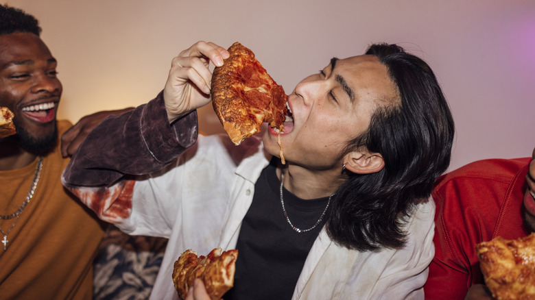 Young men eating pizza
