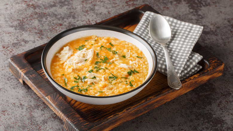 a bowl of Italian penicillin soup in a bowl on a wooden board