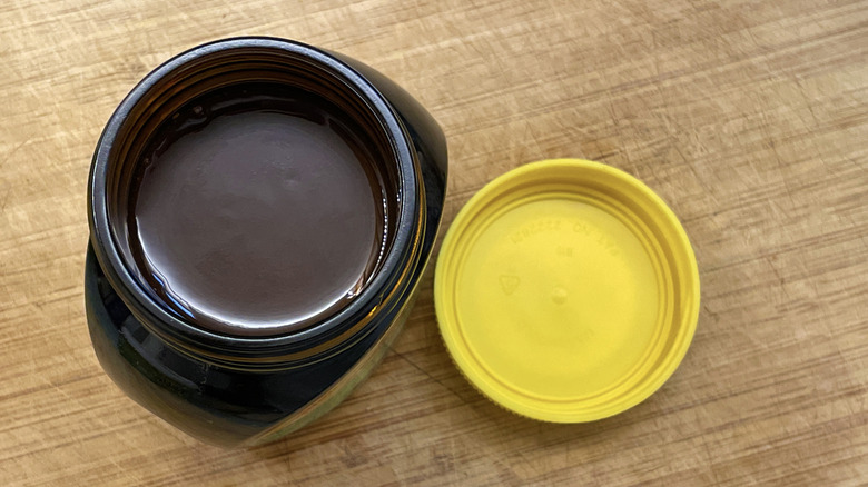 Opened jar of Marmite yeast extract on a wooden surface