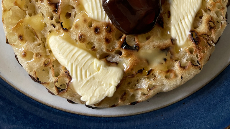 Spreading Marmite onto buttered crumpet
