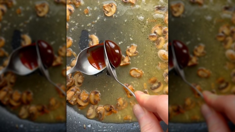 Spooning Marmite into pan of saucy sauteed mushrooms