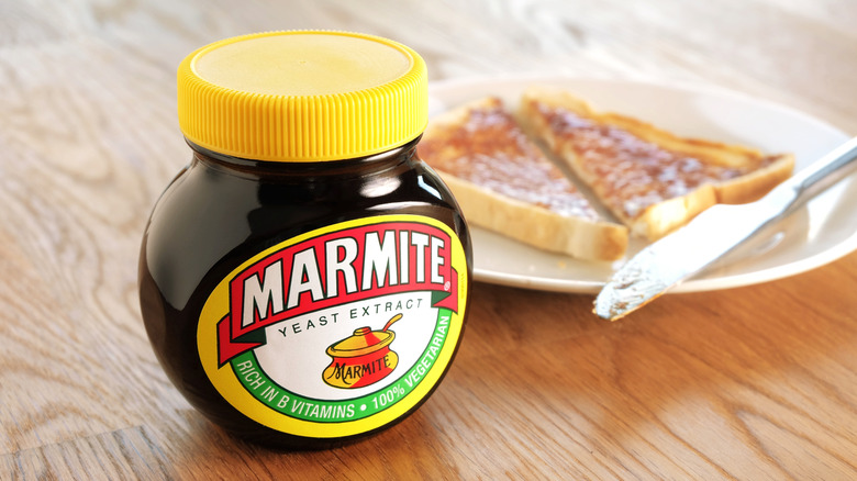 Jar of Marmite next to plate of Marmite on toast