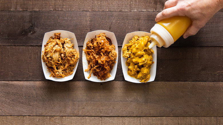 adding Carolina BBQ sauce to pulled pork