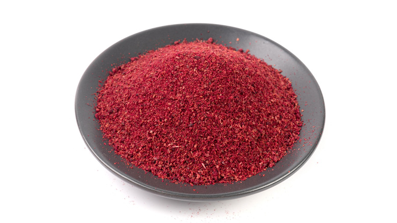 Sumac in grey bowl on white background
