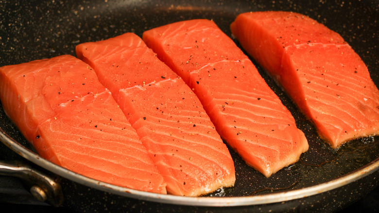 Fresh salmon filets searnig in a pan