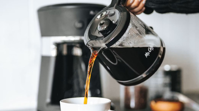 Pouring drip coffee from Mr. Coffee glass carafe