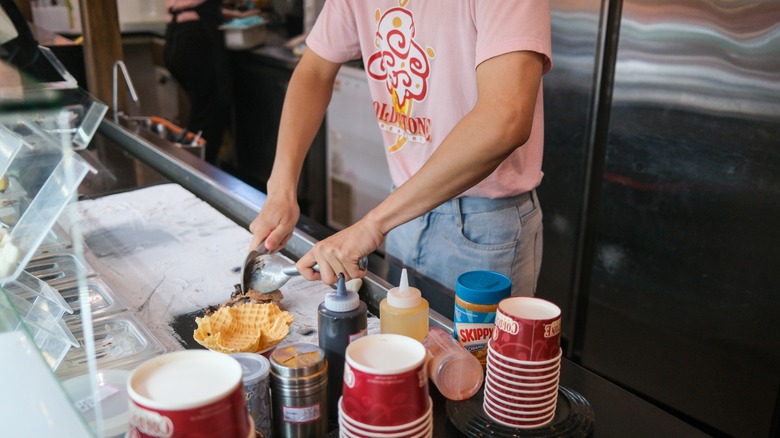 Employee at Cold Stone Creamery using the stone
