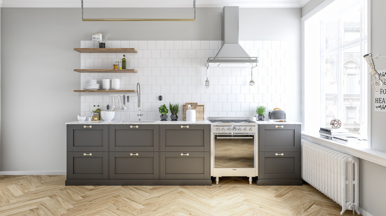 herringbone kitchen floors with grey kitchen cabinets and white walls to create a spacious kitchen