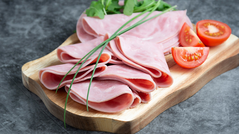 Turkey ham slices on cutting board with tomatoes
