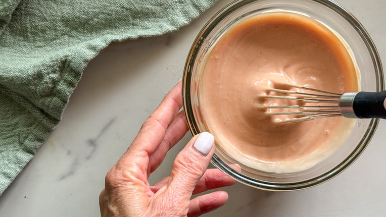Whisking yum yum sauce in glass bowl