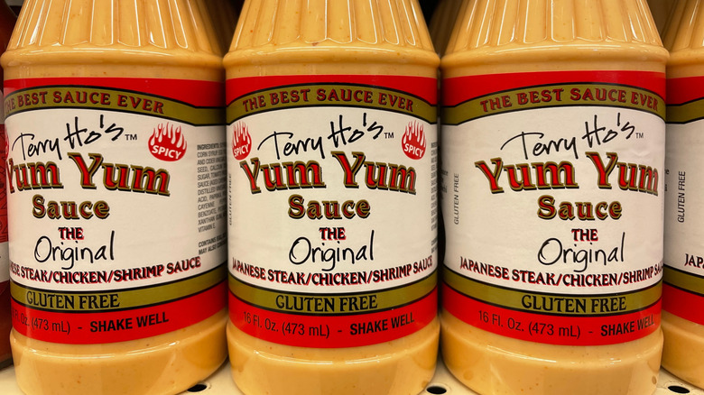 Bottles of yum yum sauce lined up on grocery store shelf
