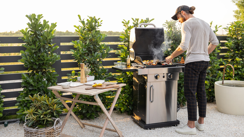 man using outdoor grill