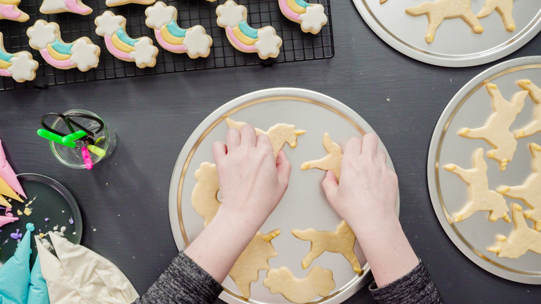 person arranging plate of sugar cookies